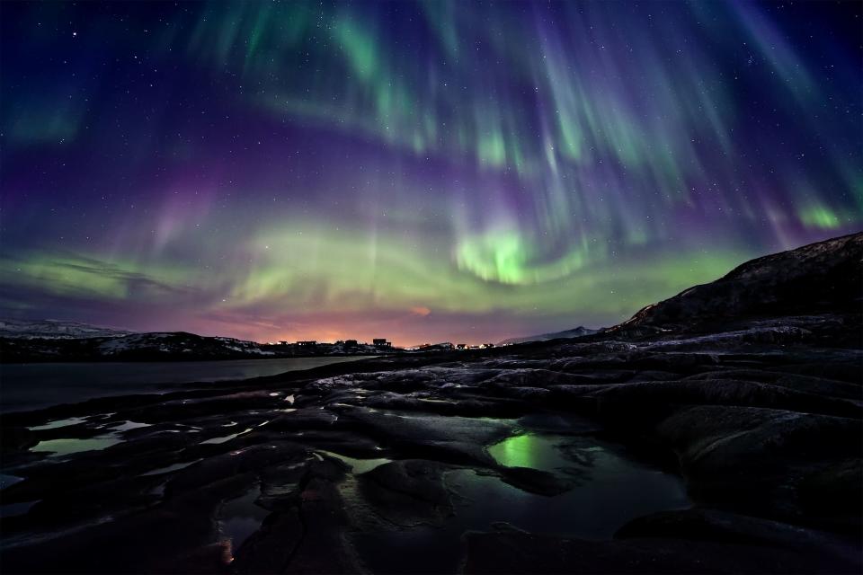 Runner-up (Earth & Space), 'Divine Presence' by Ole C. Salomonsen (Norway). Display of the Aurora Borealis, or Northern Lights, taken over ponds near Hillesøy in Norway, 11 March 2011. The aurorae are caused by the interaction between the Earth’s atmosphere and a stream of particles from the Sun known as the solar wind. The Earth’s magnetic field funnels these particles down over the planet’s poles giving rise to the glowing curtains of coloured light.