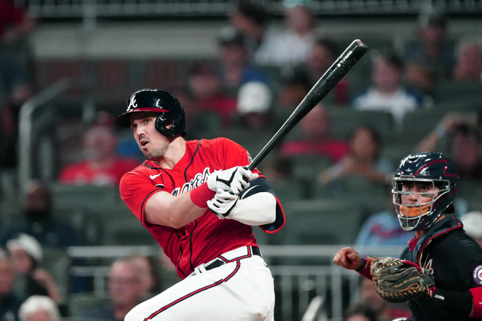 Atlanta Braves' Adam Duvall, left, drives in a run with a double as Washington Nationals catcher Tres Barrera looks on in the fifth inning of a baseball game Friday, Aug. 6, 2021, in Atlanta. (AP Photo/John Bazemore)