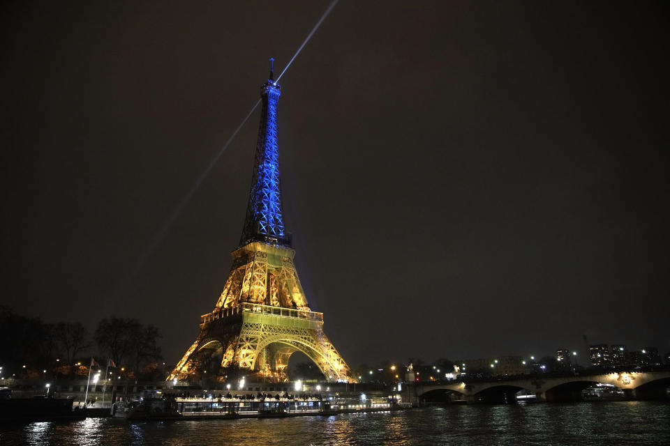 La Torre Eiffel, iluminada con los colores de la bandera de Ucrania en la víspera del primer aniversario de la invasión rusa del país, en París, Francia, el 23 de febrero de 2023. (AP Foto/Christophe Ena)