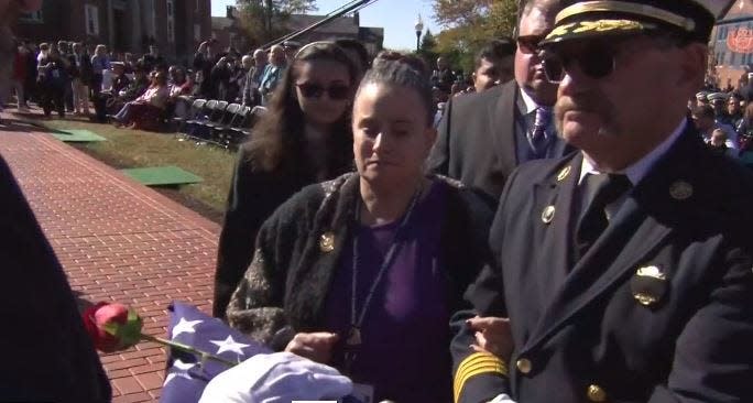 Jacksonville Fire and Rescue Department Lt. Mario Moya's family accepts a folded American flag during last weekend's National Fallen Firefighters Memorial in Maryland.