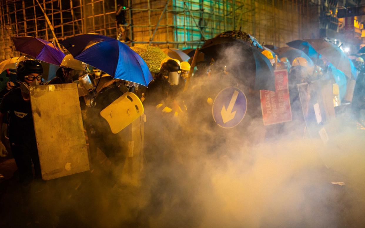 Protesters are enveloped by tear gas on street during a demonstration in the area of Sheung Wan  in Hong Kong - Getty Images AsiaPac