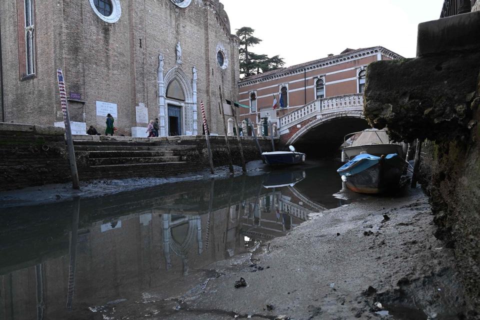 This photograph taken on February 20, 2023, shows gondola tied up in Venice Canal Grande, during a severe low tide in the lagoon city of Venice.