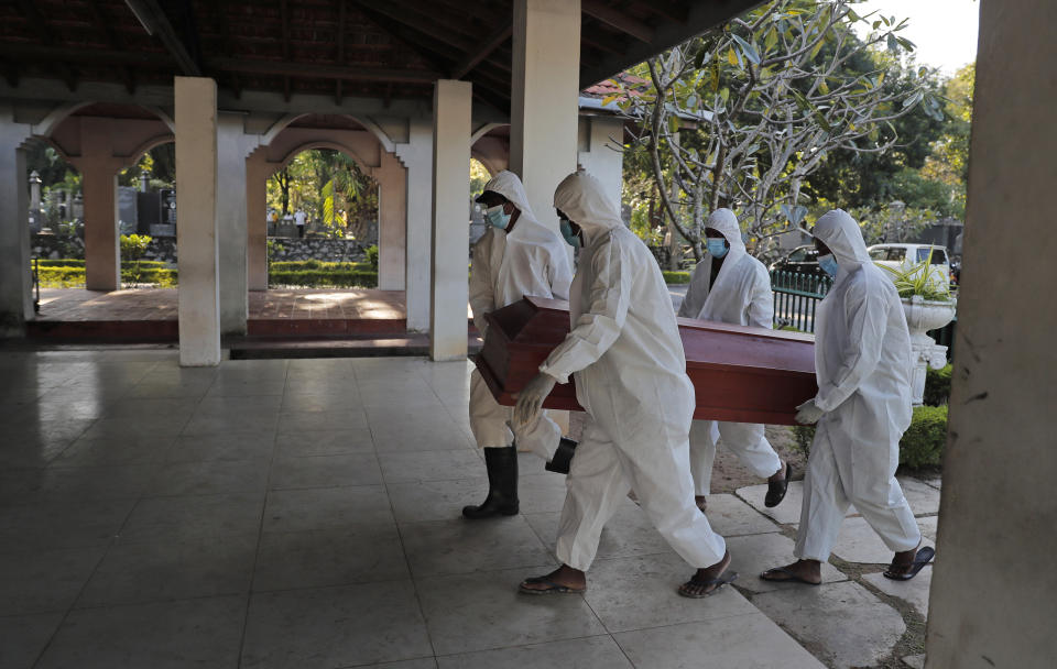 Sri Lankan municipal workers carry the coffin of a COVID-19 victim at a cemetery in Colombo, Sri Lanka, Friday, Jan. 22, 2021. Sri Lanka on Friday approved the Oxford-AstraZeneca vaccine for COVID-19 amid warnings from doctors that front-line health workers should be quickly inoculated to stop the system from collapsing. (AP Photo/Eranga Jayawardena)