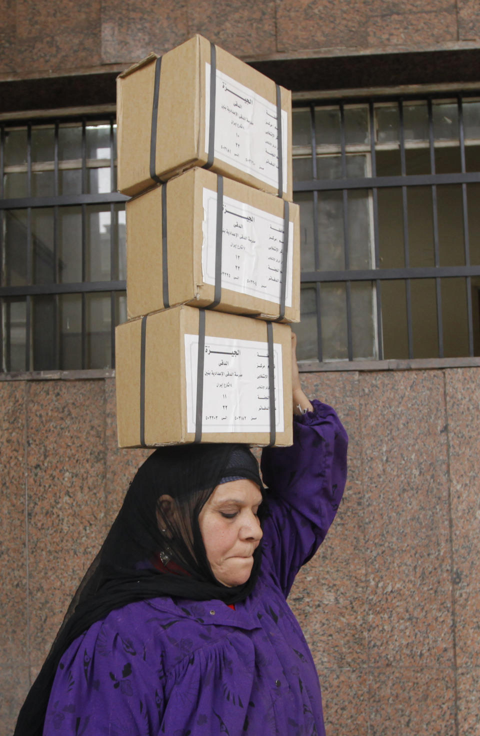 An Egyptian worker carries boxes of ballots in preparation for a vote on Egypt's new constitution, at the Giza courthouse, in Cairo, Egypt, Monday, Jan. 13, 2014. The January 14-15 vote on the draft constitution will be the first real test of the post-Morsi regime. A comfortable "yes" vote and a respectable turnout would be seen as bestowing legitimacy, while undermining the Islamists' argument that Morsi remains the nation's elected president. (AP Photo/Amr Nabil)