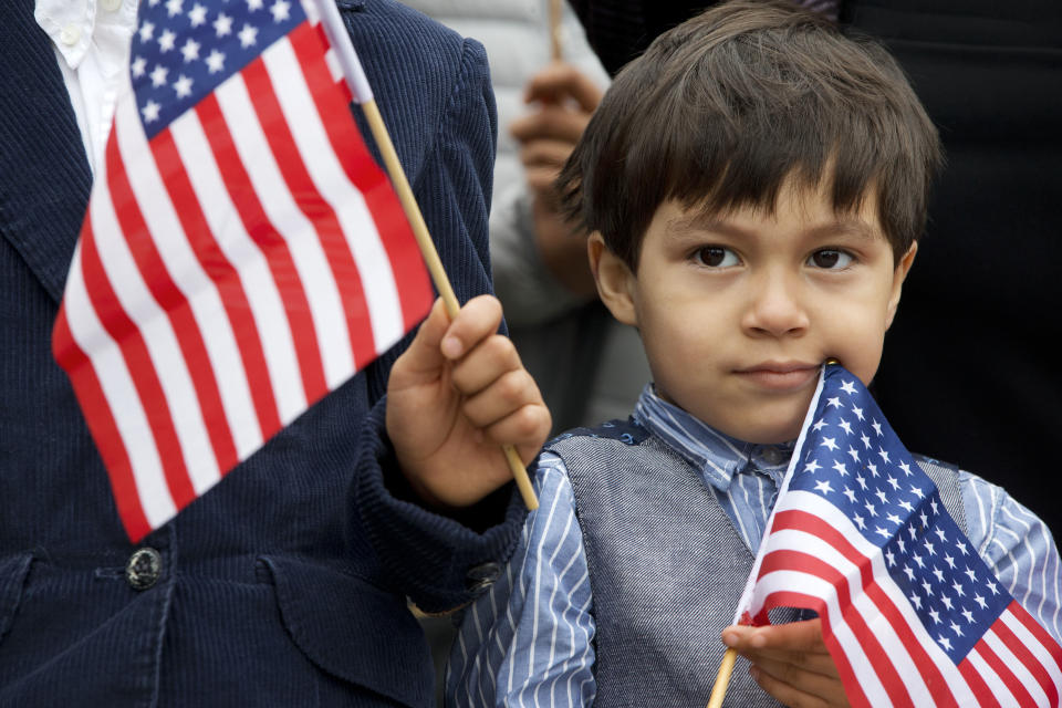 Iker Velasquez, 4, who came from Honduras with his parents, holds a U.S. glad as he listens while Rep. Luis Gutierrez, D-Ill., speaks to the media with children and families from Central America, to speak about the conditions for Central American immigrants who he describes as refugees from violence, during a news conference on Capitol Hill in Washington, Wednesday, May 18, 2016. (AP Photo/Jacquelyn Martin)