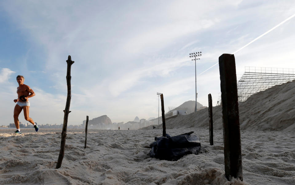 A man runs near a part of a mutilated body near the construction site of the beach volleyball venue for 2016 Rio Olympics on Copacabana beach in Rio de Janeiro, Brazil, June 29, 2016. REUTERS/Sergio Moraes TPX IMAGES OF THE DAY