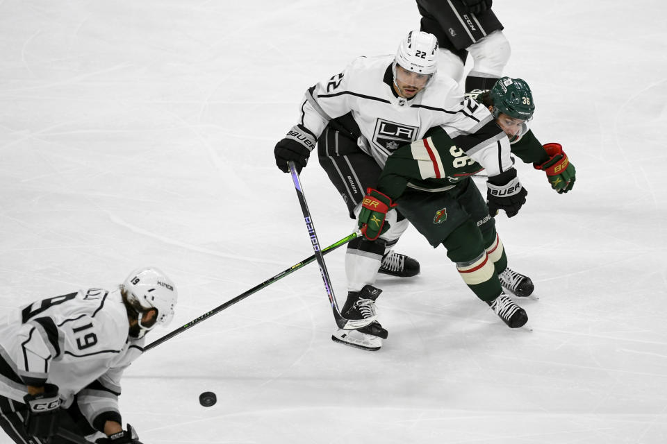Los Angeles Kings left wing Kevin Fiala (22) and Minnesota Wild right wing Mats Zuccarello (36) battle for control of the puck during the third period of an NHL hockey game Tuesday, Feb. 21, 2023, in St. Paul, Minn. Minnesota won 2-1. (AP Photo/Craig Lassig)
