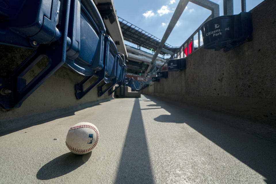 FILE - In this Sunday, July 26, 2020, file photo, a foul ball that was hit into the stands sits on the ground of an empty stadium during the eighth inning of a baseball game between the Miami Marlins and the Philadelphia Phillies in Philadelphia. The Marlins’ coronavirus outbreak could endanger the Major League Baseball season, Dr. Anthony Fauci said, as the number of their players testing positive rose to 15. The Marlins received positive test results for four additional players Tuesday, July 23, 2020, a person familiar with the situation told The Associated Press. The person declined to be identified because the results had not been publicly released. (AP Photo/Chris Szagola, File)