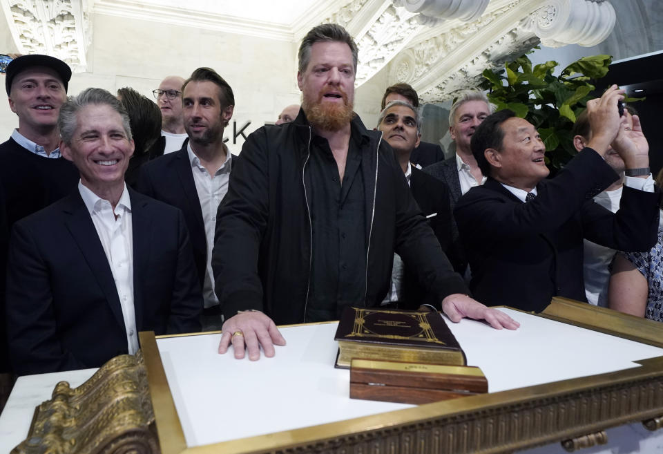 Birkenstock CEO Oliver Reichert, center, poses for photos on the New York Stock Exchange trading floor prior to ringing the opening bell before his company's IPO, Wednesday, Oct. 11, 2023. (AP Photo/Richard Drew)