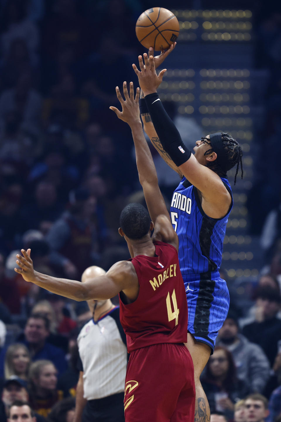 Orlando Magic forward Paolo Banchero (5) shoots against Cleveland Cavaliers forward Evan Mobley (4) during the first half of an NBA basketball game Friday, Dec. 2, 2022, in Cleveland. (AP Photo/Ron Schwane)