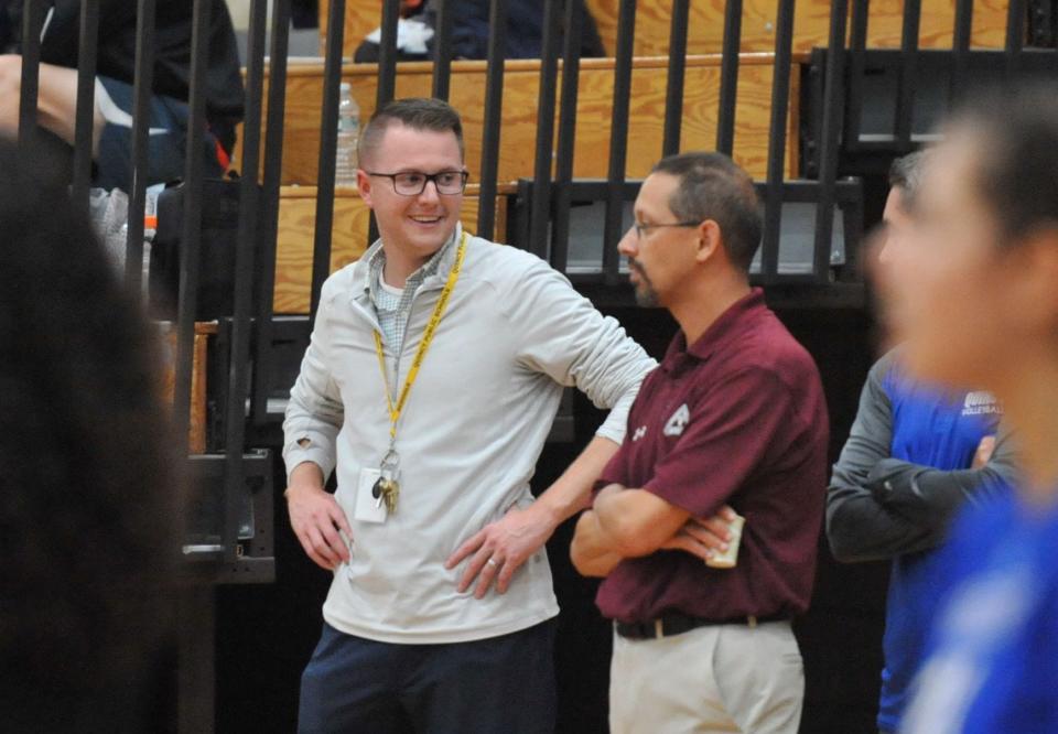 Quincy/North Quincy Athletic Director Kevin Mahoney, left, chats with staff members during a girls volleyball game between the Presidents and the Raiders in September.