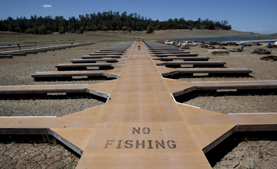 Empty boat docks sit on dry land at the Browns Ravine Cove area of drought-stricken Folsom Lake, currently at 37% of its normal capacity, in Folsom, Calif., Saturday, May 22, 2021. California Gov. Gavin Newsom declared a drought emergency for most of the state. (AP Photo/Josh Edelson)