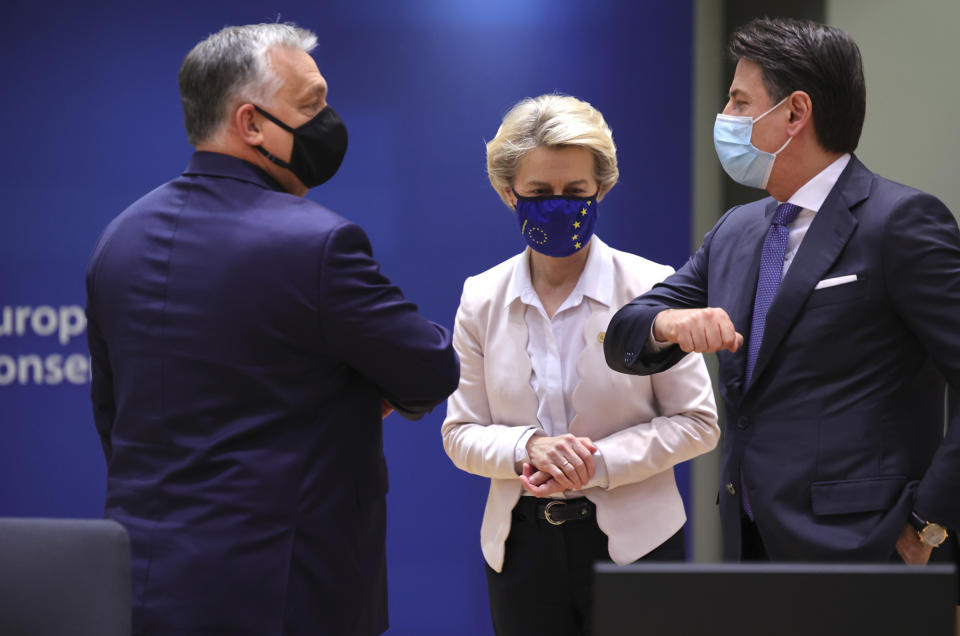 European Commission President Ursula von der Leyen, center, looks on as Hungary's Prime Minister Viktor Orban, left, greets Italy's Prime Minister Giuseppe Conte during a round table meeting at an EU summit in Brussels, Thursday, Dec. 10, 2020. European Union leaders meet for a year-end summit that will address anything from climate, sanctions against Turkey to budget and virus recovery plans. Brexit will be discussed on the sidelines. (AP Photo/Olivier Matthys, Pool)