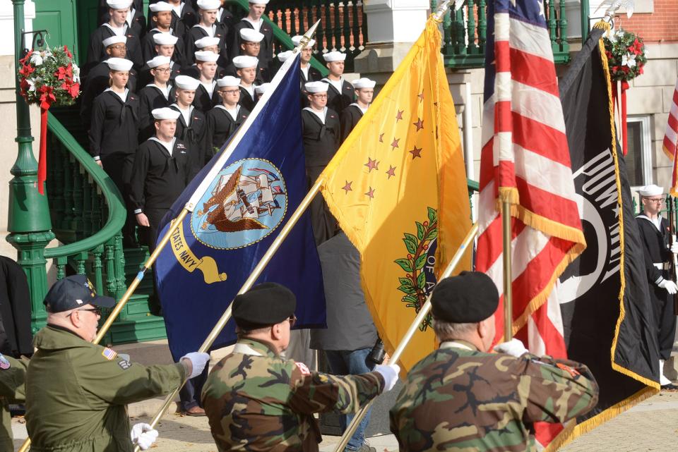 A color guard of Vietnam War veterans join sailors from the Naval Submarine School in New London Tuesday during Pearl Harbor Remembrance Day at Norwich City Hall. 