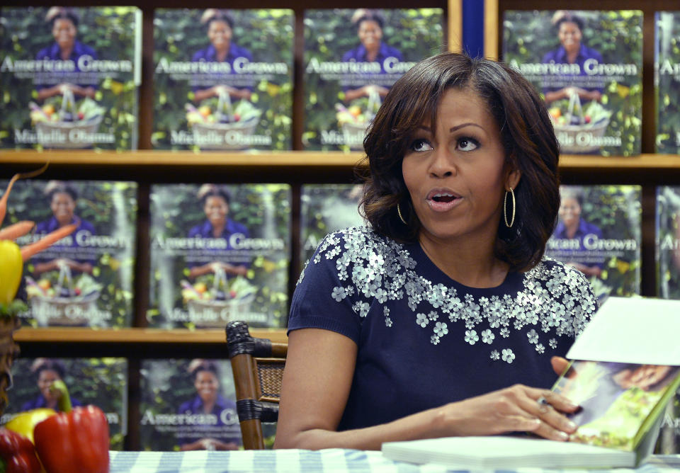 US First Lady Michelle Obama signs a copy of her book 'American Grown: The Story of the White House Kitchen Garden and Gardens Across America,' during a book signing event at Politics & Prose in Washington, DC, on May 7, 2013. Photo credit:  JEWEL SAMAD/AFP/Getty Images