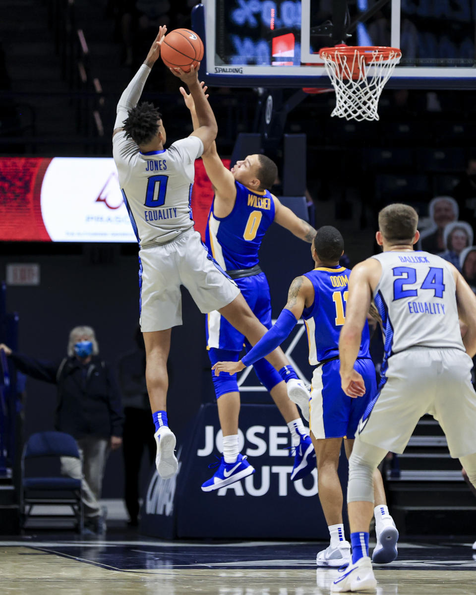 Creighton guard Antwann Jones, left, attempts to shoot against Xavier guard C.J. Wilcher (0) in the first half of an NCAA college basketball game, Saturday, Feb. 27, 2021, in Cincinnati. (AP Photo/Aaron Doster)