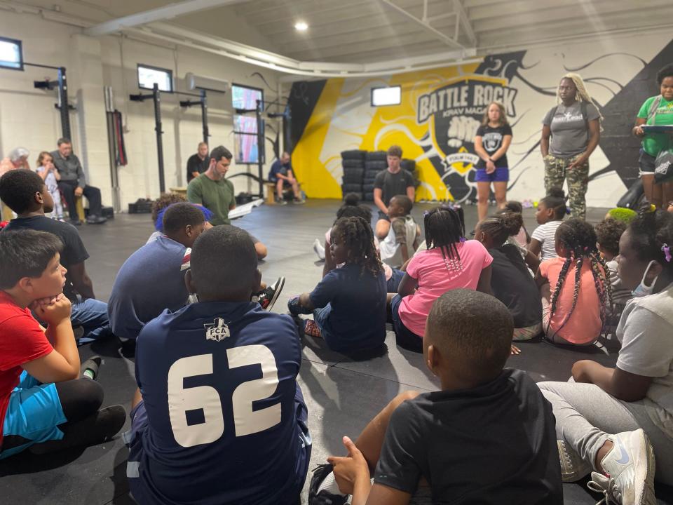 Todd Mills talks with a group of children from Emerald Youth at the Battle Rock Krav Maga gym, Fountain City.