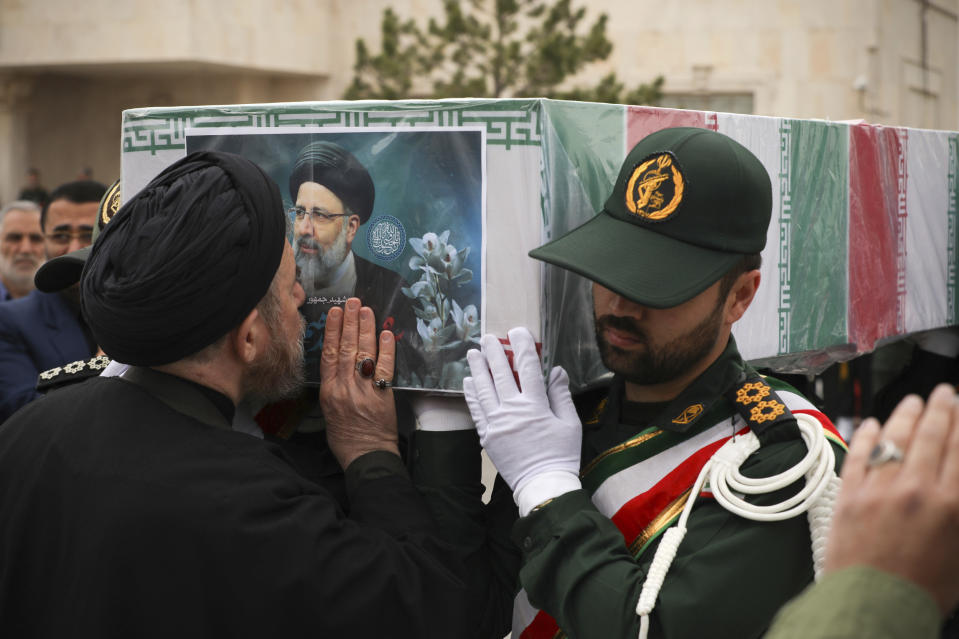 In this photo released by the Iranian Presidency Office, a cleric kisses the flag-draped coffin of President Ebrahim Raisi during a funeral ceremony for him and his companions who were killed in a helicopter crash on Sunday in a mountainous region of the country's northwest, in the city of Tabriz, Iran, Tuesday, May 21, 2024. (Iranian Presidency Office via AP)
