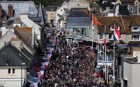 Visitors walk in a street of Arromanches in Normandy - Credit: AFP