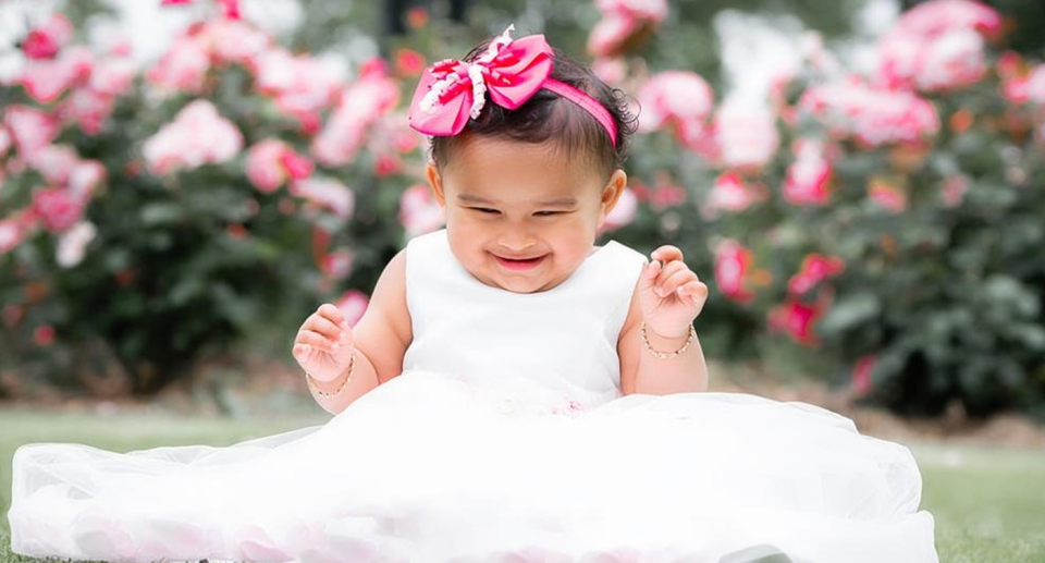 Kreya Patel pictured in a white dress, and with a pink bow in her hair.