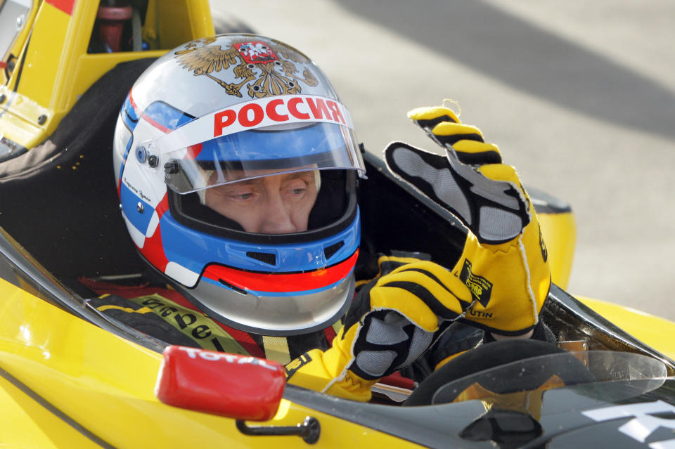 Russian Prime Minister Vladimir Putin wears a helmet and the uniform of the Renault Formula One team before driving a F1 race car on a special track in Leningrad region outside St. Petersburg on Nov. 7, 2010.