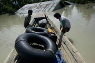 Residents transport rubber tubes on a raft over floodwaters in Kalay, upper Myanmar's Sagaing region, on August 2, 2015