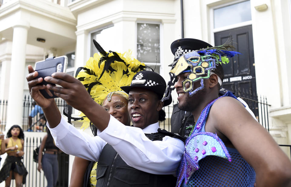 <p>A police offer takes a selfie with performers during the Notting Hill Carnival on August 29, 2016 in London, England. (Photo by Ben A. Pruchnie/Getty Images) </p>