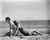 <p>Joan Crawford leans on husband Douglas Fairbanks Jr. while taking it easy in the sand.</p>