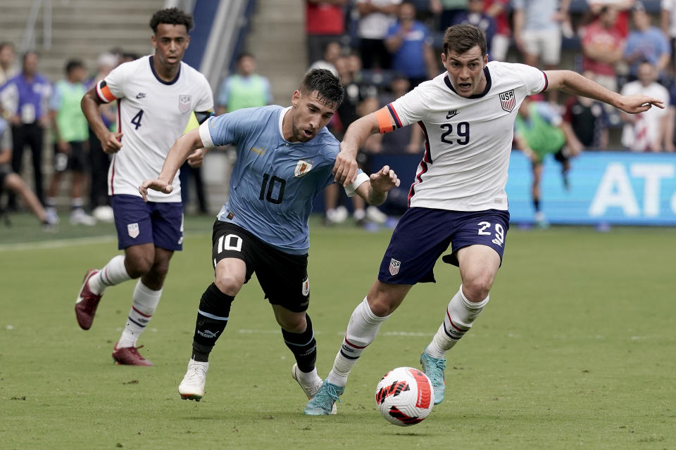 Uruguay midfielder Fernando Gorriaran (10) and USA defender Joe Scally (29) chase the ball during the first half of an international friendly soccer match Sunday, June 5, 2022, in Kansas City, Kan. (AP Photo/Charlie Riedel)