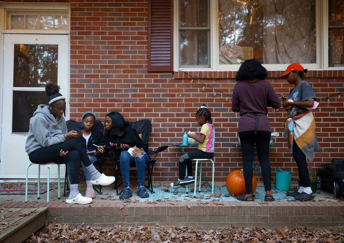 From left, sisters Ahava, 16, Abby, 12, Sarah, 15, Hannah, 5, and Chiyrah, 19, relax on the porch with their mother, Sheba Everett, at their home in Durham, N.C. on Thursday, Nov. 3, 2022. Kaitlin McKeown/kmckeown@newsobserver.com