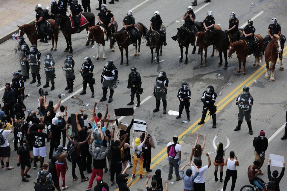 Protesters stand in the middle of Broad Street in May as Columbus Division of Police officers and mounted patrol attempt to move them from the area.