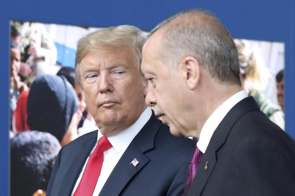 FILE - In this July 11, 2018 file photo, President Donald Trump, left, talks to Turkish President Recep Tayyip Erdogan as they tour the new NATO headquarters in Brussels, Belgium. Trump’s decision to withdraw American troops from Syria was made hastily, without consulting his national security team or allies, and over the strong objections of virtually everyone involved in the fight against the Islamic State, according to U.S. officials. Trump stunned his Cabinet, lawmakers and much of the world with the move that triggered Defense Secretary Jim Mattis’ resignation by rejecting the advice of his top aides and agreeing to the pull-out in a phone call with Turkish President Recep Tayyip Erdogan last week, two officials briefed on the matter said. (Tatyana Zenkovich/pool photo via AP)