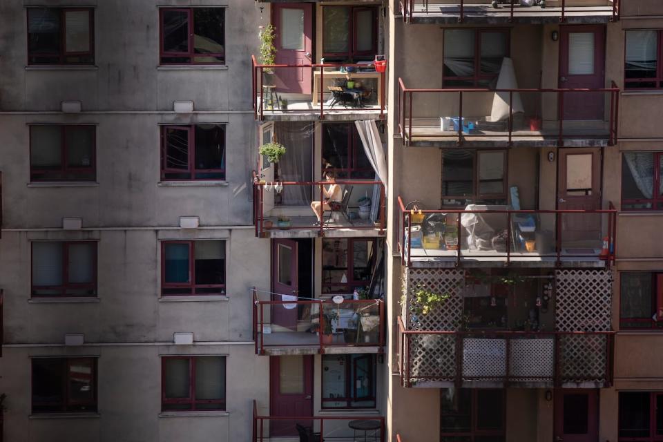 A woman sits on her balcony during a hot period of weather in Vancouver on July 20, 2022.