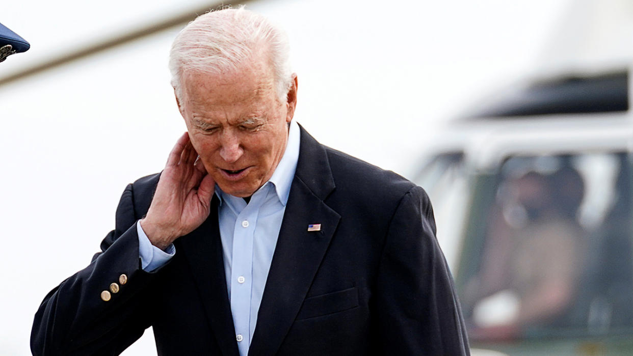 President Biden swats away a cicada (not seen) that was flying around his head prior to boarding Air Force One at Joint Base Andrews Wednesday. (Kevin Lamarque/Reuters)