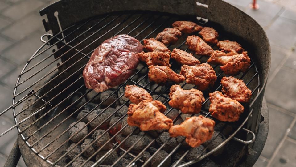 An assortment of meats sit on a grill