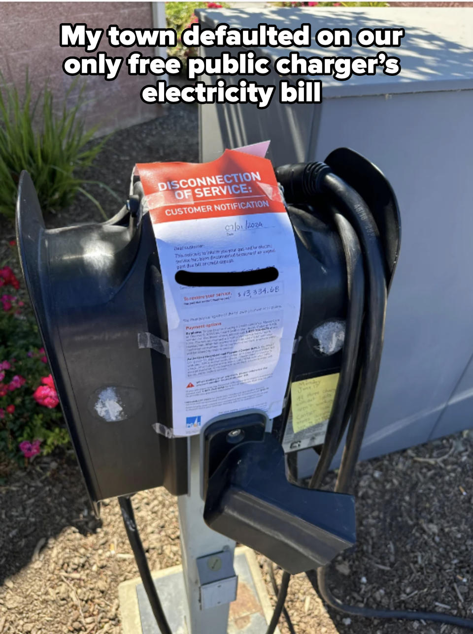 Electric vehicle charging station with an attached notice labeled "Disconnection of Service" and customer notification text