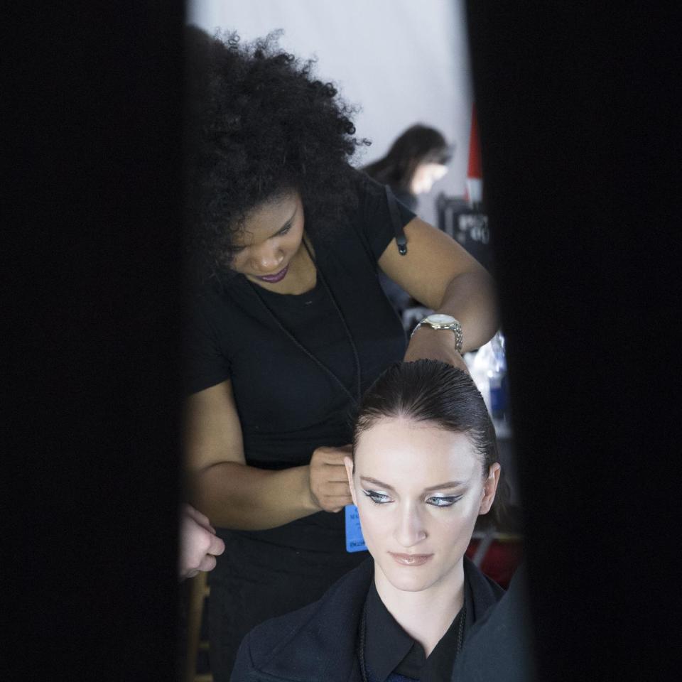 A model's hair is prepped backstage before the Carmen Marc Valvo Fall 2014 collection is modeled during Fashion Week, Friday, Feb. 7, 2014, in New York. (AP Photo/John Minchillo)