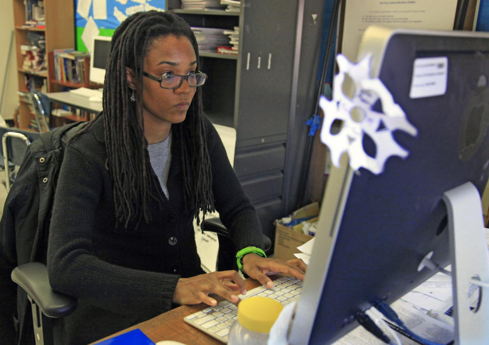 In this April 4, 2012 photo, Nkomo Morris, a teacher at Brooklyn's Art and Media High School, works on her classroom computer in New York. Morris, who teaches English and journalism, said she has about 50 current and former students as Facebook friends. That could be a problem if the new rules instruct teachers not to friend students. (AP Photo/Bebeto Matthews)