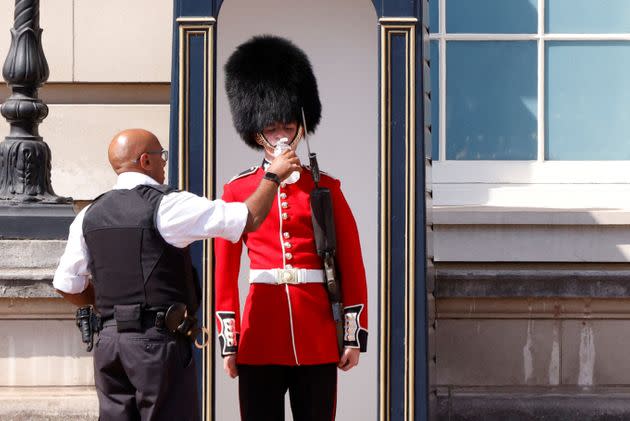 A member of the Queen's Guard receives water to drink during the hot weather, outside Buckingham Palace in London. (Photo: JOHN SIBLEY via REUTERS)