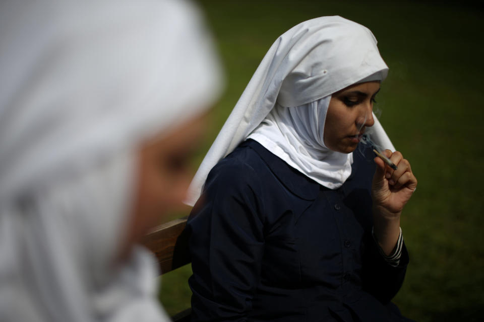 California "weed nun" Desiree Calderon, who goes by the name Sister Freya (L), and India Delgado, who goes by the name Sister Eevee, smoke a joint at Sisters of the Valley near Merced, California, U.S., April 18, 2017. Picture taken April 18, 2017. REUTERS/Lucy Nicholson