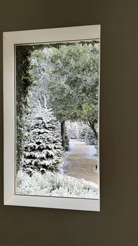 <p>Kim Kardashian/Instagram</p> The view from Kardashian's window that overlooks snow-covered evergreens and a cleared pathway.