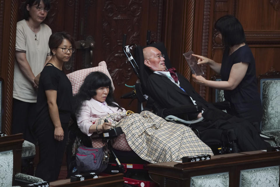 Newly-elected lawmakers in wheelchairs, Eiko Kimura, center left, and Yasuhiko Funago, of the opposition party Reiwa Shinsengumi, attend the opening of an extraordinary Diet session at the upper house of parliament Thursday, Aug. 1, 2019. Funago has amyotrophic lateral sclerosis and Eiko Kimura has cerebral palsy. They represent an opposition group led by actor-turned-politician Taro Yamamoto.(AP Photo/Eugene Hoshiko)