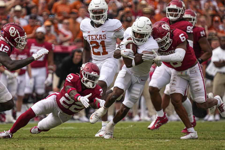 Texas running back Keilan Robinson tries to avoid being tackled by two Oklahoma defenders during their 2022 game at the Cotton Bowl. The Longhorns and Sooners secured an early exit from the Big 12 in time for the 2024 season when they join the Southeastern Conference.