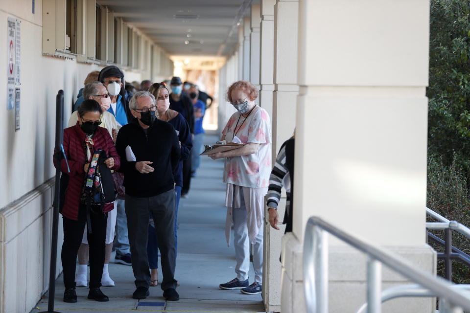 A Florida Department of Health employee helps a senior who is getting the COVID-19 vaccine as people of 65 and over wait in line at the DOH Sarasota COVID-19 Vaccination Clinic in Sarasota, Florida, U.S. January 4, 2021. REUTERS/Octavio Jones