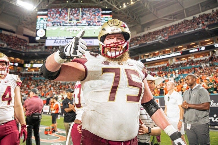 Florida State left guard Dillan Gibbons poses for a picture after breaking his face mask against Miami last Saturday.