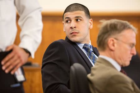 New England Patriots tight end Aaron Hernandez watches as the owner of the New England Patriots Robert Kraft enters the courtroom during his murder trial at Bristol County Superior Court in Fall River, Massachusetts, March 31, 2015. REUTERS/Aram Boghosian/Pool