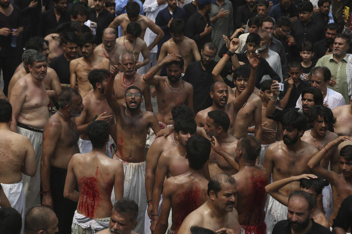Shiite Muslims flagellate themselves with knives on chains during a Muharram procession, in Peshawar, Pakistan, Monday, Aug. 8, 2022. Muharram, the first month of the Islamic calendar, is a month of mourning for Shiites in remembrance of the death of Hussein, the grandson of the Prophet Muhammad, at the Battle of Karbala in present-day Iraq in the 7th century. (AP Photo/Muhammad Sajjad)