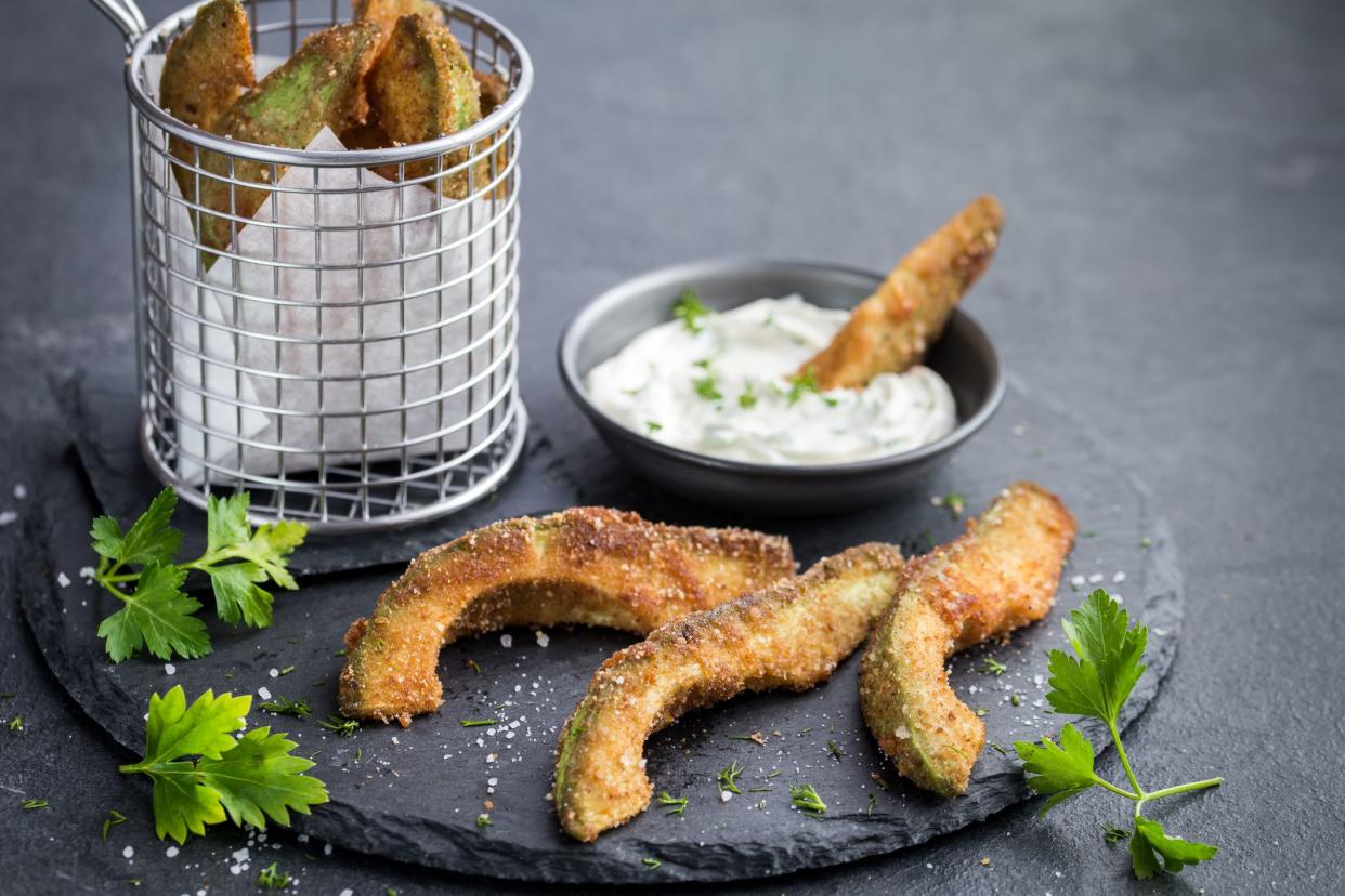 crispy avocado fries with garlic yogurt sause. Dark background