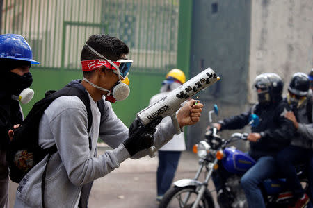 Demonstrator prepares to fire a homemade mortar with a sign reads, "Resist Venezuela" during rally against Venezuela's President Nicolas Maduro in Caracas, Venezuela May 1, 2017. REUTERS/Carlos Garcia Rawlins