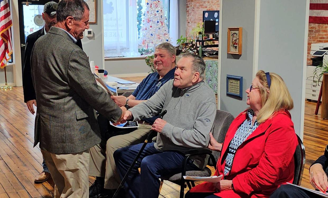 M. Richard Mellon, left, shakes hands with former Gov. Tom Ridge on Saturday at the North East office of state Rep. Jake Banta. Ridge's wife, Michele, and U.S. Rep. Mike Kelly, R-16th Dist., are seated to the left of Ridge.